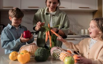 A family enjoys quality time in the kitchen, preparing a meal with fresh vegetables.