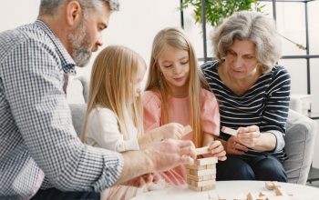 A family enjoying time together playing a block stacking game in their living room.